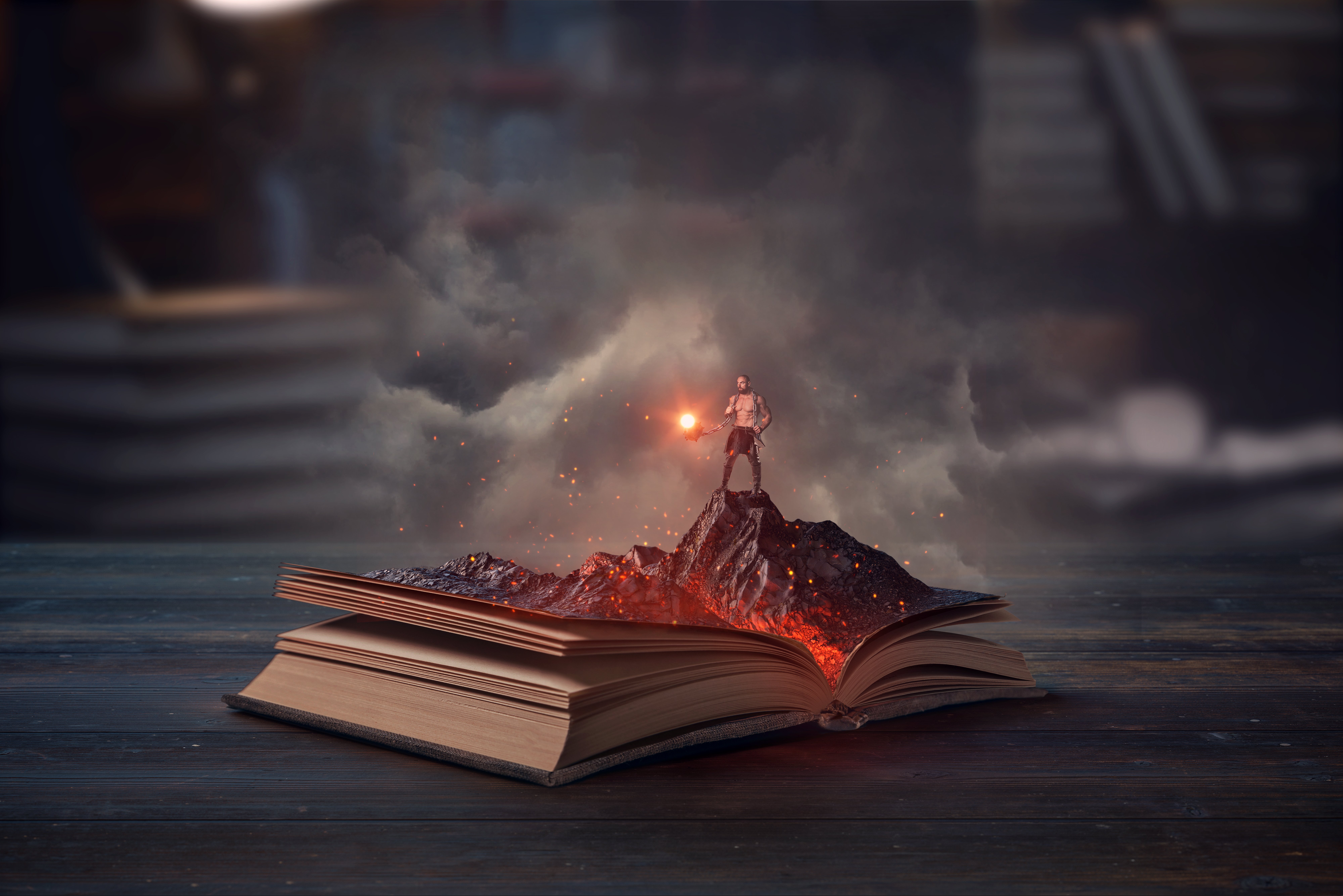 Open book with a fantasy mountain erupting from its pages and a warrior figure holding a glowing orb.